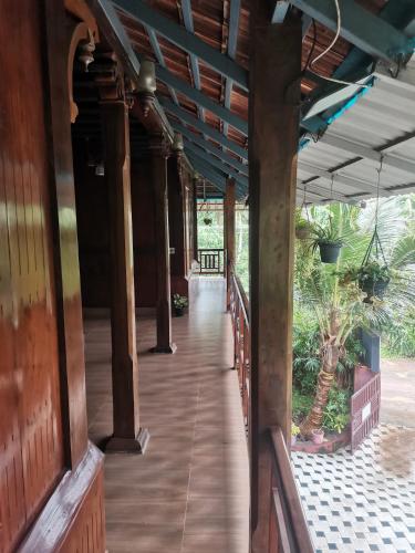 an empty porch of a house with a wooden floor at Kailasahomestay & Ayurvedic Spa in Pūvār