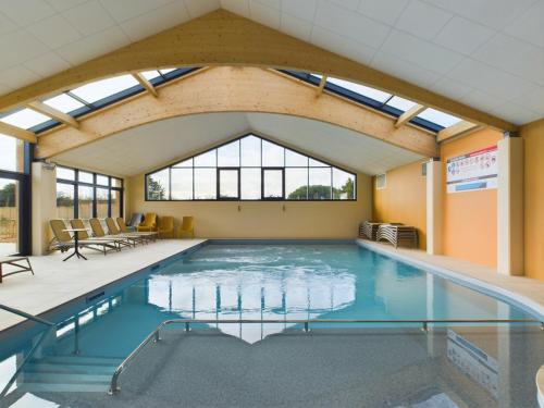 une piscine dans un immeuble avec une grande fenêtre dans l'établissement Chalet pour 4 - Domaine avec piscine, à Saint-Gilles-Croix-de-Vie
