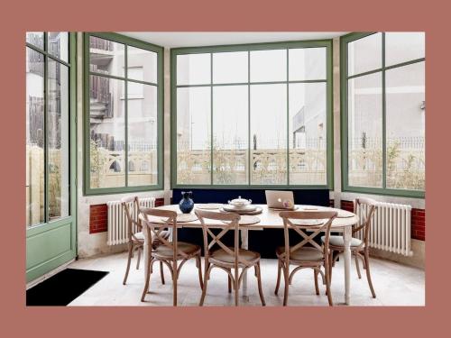 - une salle à manger avec une table, des chaises et un ordinateur portable dans l'établissement Villa de luxe face à la mer - 3763, à Soulac-sur-Mer