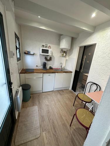 eine kleine Küche mit einem Tisch und Stühlen darin in der Unterkunft Timounyan T1 N24 centre ville Animaux acceptés in Arcachon