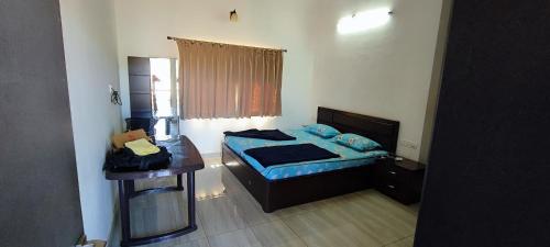 ein kleines Schlafzimmer mit einem Bett und einem Schreibtisch in der Unterkunft Eagle Eye Resort in Mahabaleshwar