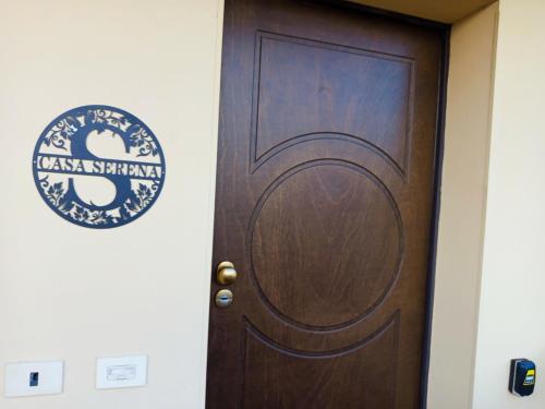 a wooden door with a sign on a wall at casa serena a Carmignano (Seano) vicino a Firenze in Seano