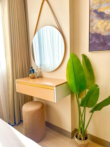 a dressing table with a mirror and a plant at The Mactan Newtown Beach Condo in Lapu Lapu City