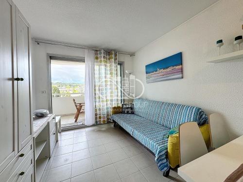 un salon avec un canapé et une fenêtre dans l'établissement 2P 5 min de la plage - Juan-les-Pins, à Antibes