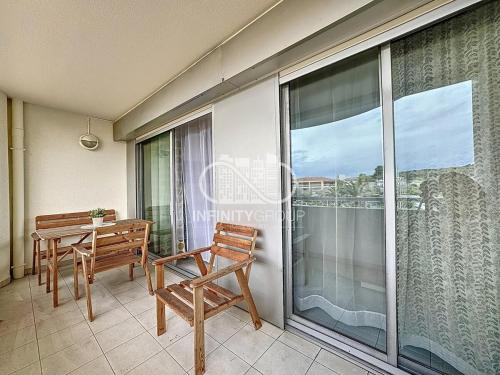 un balcon avec une table, des chaises et une fenêtre dans l'établissement 2P 5 min de la plage - Juan-les-Pins, à Antibes