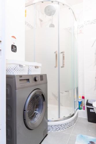 une machine à laver dans une salle de bain avec douche dans l'établissement T2 a stone's throw from Gare Amiens, à Amiens