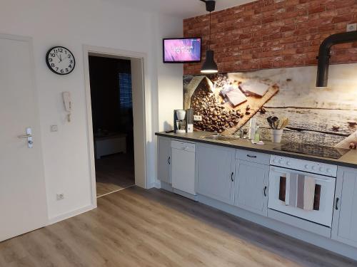 a kitchen with white cabinets and a brick wall at Ferienwohnungen _ Haus Lisa_ in Senftenberg