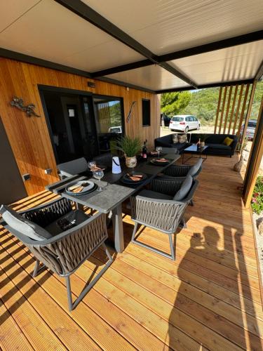 eine Terrasse mit Tisch und Stühlen auf einem Deck in der Unterkunft Beach House Gabriela in Tisno