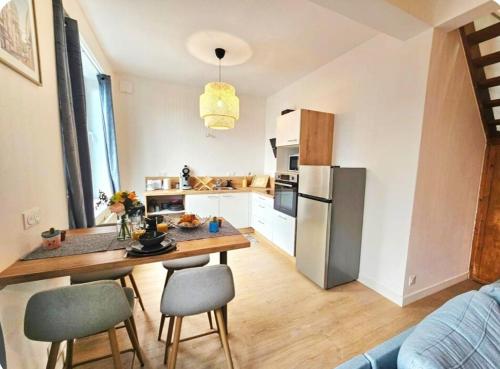 une cuisine avec une table et un réfrigérateur dans l'établissement Lumineux Duplex proche Place Dalton et Remparts, à Boulogne-sur-Mer