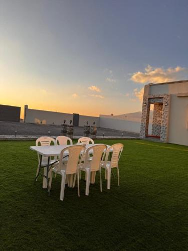 a white table and chairs sitting on the grass at Suhail Star Guest House in Misfāh