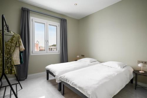 a bedroom with two beds and a window at Comme a la maison in Corfu Town