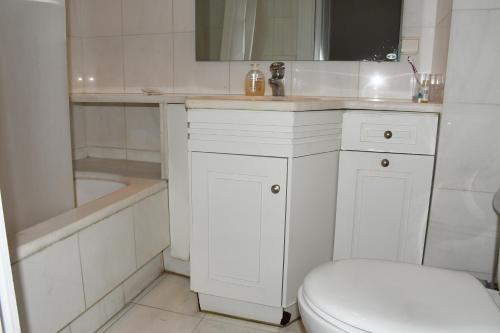 Un baño blanco con inodoro y lavabo. en Adrianos Gate View Apartment, en Atenas