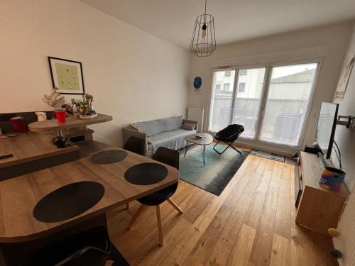 un salon avec une table et un canapé dans l'établissement Appartement partagé avec jardin - métro 11 & 9, à Montreuil