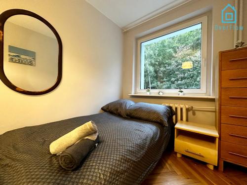 a bedroom with a bed and a large mirror at Surf Room - 5 Minutes to Sopot Molo & Seaside in Sopot