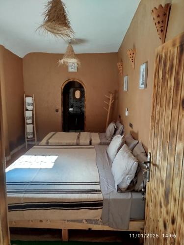 a bedroom with two beds in a room at Dar Nomads in Mhamid