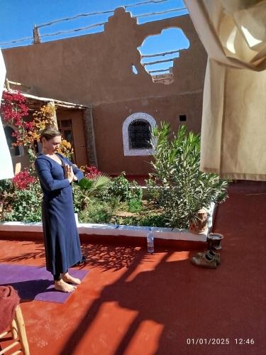 a woman standing in front of a building at Dar Nomads in Mhamid