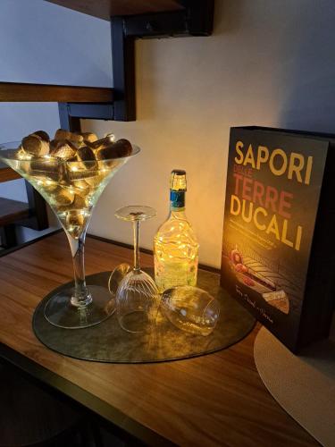 a book and a martini and a bottle of alcohol on a table at Frabosa Loft in Turin