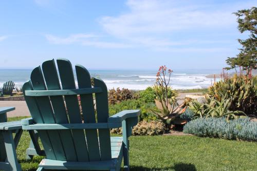a blue chair sitting on the grass near the ocean at Cambria Shores Inn in Cambria