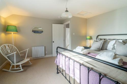 a bedroom with a bed and a chair at Holkham Skies 2 in Wells next the Sea