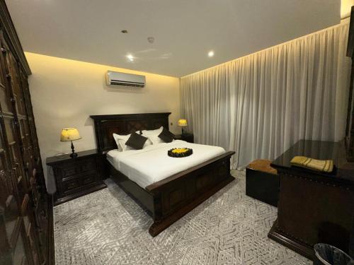 a bedroom with a bed and two nightstands at ايوان التميز للشقق الفندقية- Ewan Altamayoz Hotel Apartment in Tabuk