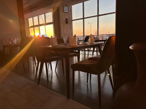 a restaurant with tables and chairs and a large window at ايوان التميز للشقق الفندقية- Ewan Altamayoz Hotel Apartment in Tabuk