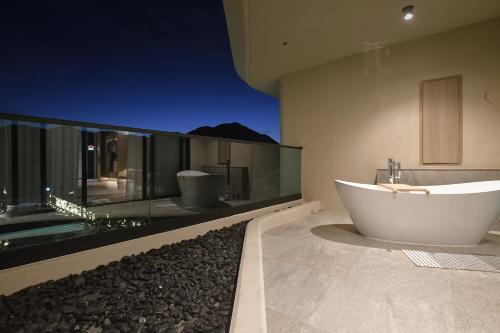 a large bathroom with a tub and a glass wall at Viewpoint Khaoyai Hotel in Mu Si