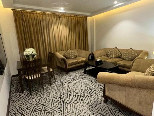 a living room with two couches and a table at ايوان التميز للشقق الفندقية- Ewan Altamayoz Hotel Apartment in Tabuk