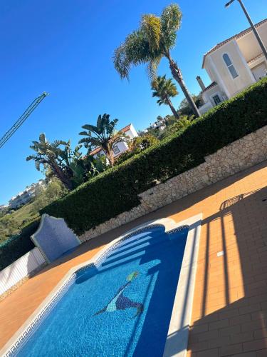 a swimming pool with dolphins painted on the side of a building at Casa Luar- suite rooms in Praia do Carvoeiro