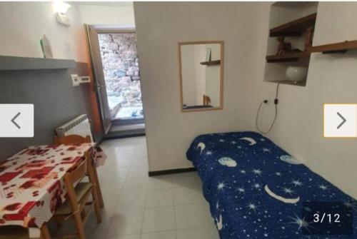 una habitación con una cama y una mesa y una ventana en Casa caterina, en Corniglia