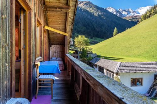 a balcony of a house with a blue table at Stifterhof App Mathilda in Rio Bianco