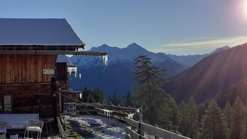 a snow covered mountain with a wooden cabin with a view at Stifterhof App Mathilda in Rio Bianco