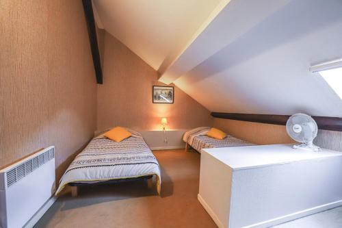 une chambre mansardée avec deux lits et une fenêtre dans l'établissement Agréable T3, à Bagnères-de-Bigorre