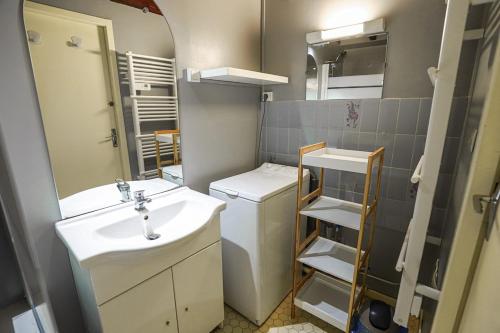 une salle de bain avec un lavabo, des toilettes et un miroir dans l'établissement Agréable T3, à Bagnères-de-Bigorre