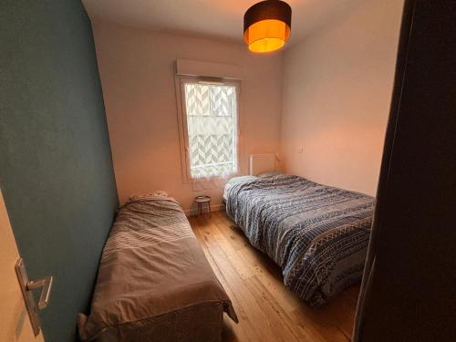 une chambre avec deux lits et une fenêtre dans l'établissement Appartement partagé avec jardin - métro 11 & 9, à Montreuil