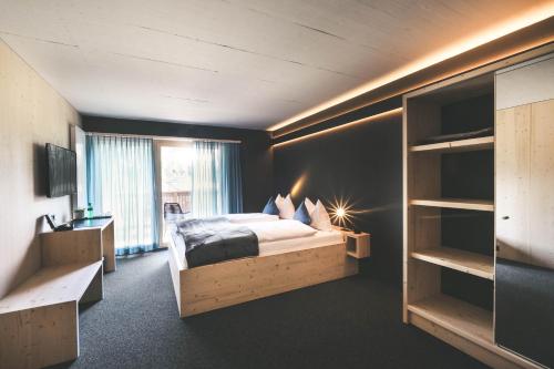 a bedroom with a large bed and a large window at Frutigresort in Frutigen