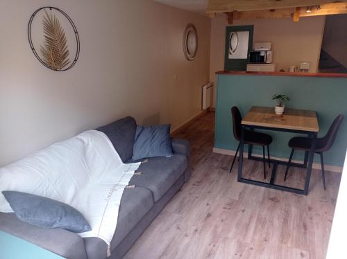 un salon avec un canapé et une table dans l'établissement Maison proche du centre ville, à Sées