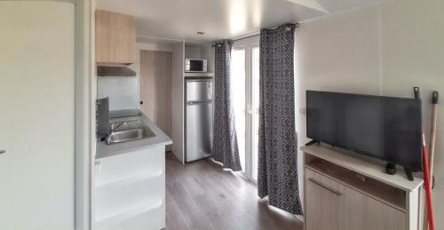 a small kitchen with a flat screen tv in a room at Bungalow with Shared Pool in Pataias + 30 m² + Pool. in Pataias