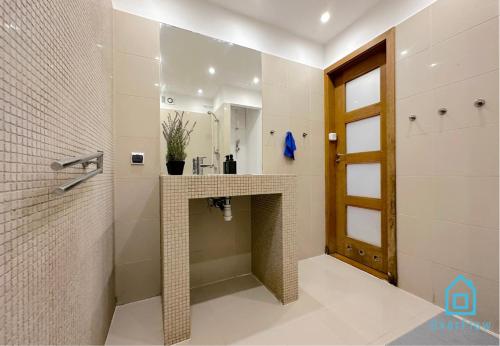 a bathroom with a shower with a sink and a mirror at Elk Room - 5 Minutes to Sopot Molo & Seaside in Sopot