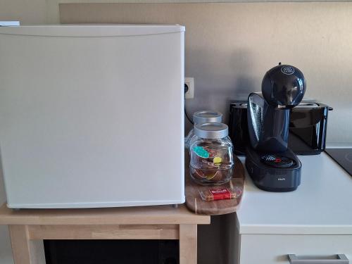 a white refrigerator sitting on a table next to a blender at La Vie en Rose in Verviers