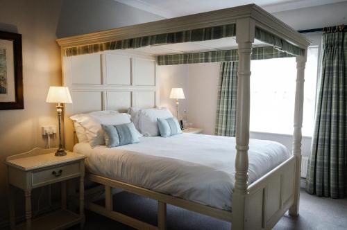ein Schlafzimmer mit einem weißen Bett mit Baldachin in der Unterkunft Conyngham Arms Hotel in Slane