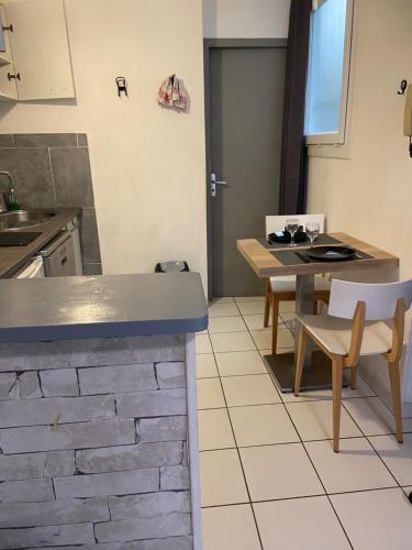 une cuisine avec un comptoir, une table et des chaises dans l'établissement Studio Triangle Arêne Gare Maison Carrée Placette, à Nîmes