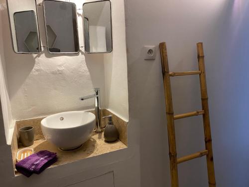 La salle de bains est pourvue d'un lavabo blanc et de miroirs. dans l'établissement Studio La Source Claire, à LʼIsle-sur-la-Sorgue