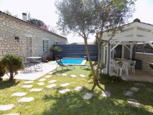 a backyard with a swimming pool and a house at Les Mathes La Palmyre - MAISON MITOYENNE en PIERRES - avec PISCINE PRIVEE in Les Mathes