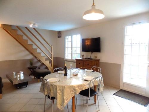 a dining room with a table and a staircase at Les Mathes La Palmyre - MAISON MITOYENNE en PIERRES - avec PISCINE PRIVEE in Les Mathes