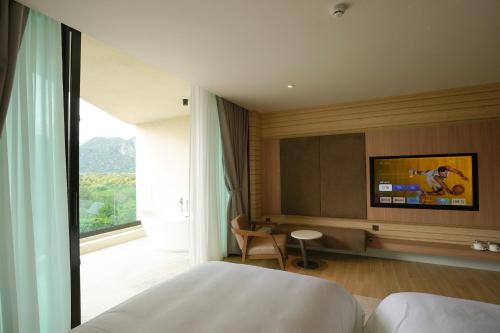 a hotel room with a bed and a television at Viewpoint Khaoyai Hotel in Mu Si