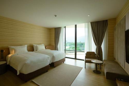 a hotel room with two beds and a large window at Viewpoint Khaoyai Hotel in Mu Si