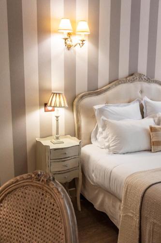 a bedroom with a bed and a table with a lamp at Hôtel du Mail in Angers