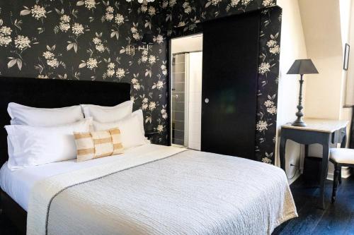 a bedroom with a bed with a black and white wall at Hôtel du Mail in Angers