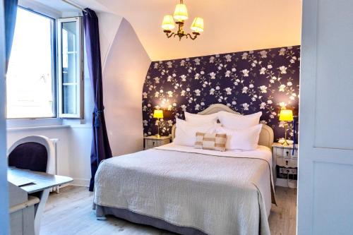 a bedroom with a bed and a wall covered in stars at Hôtel du Mail in Angers