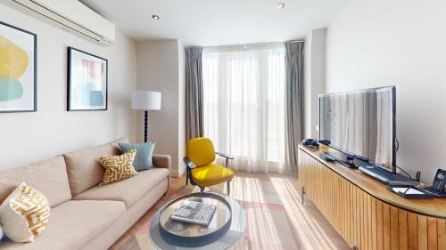 a living room with a couch and a television at Cheval Harrington Court at South Kensington in London